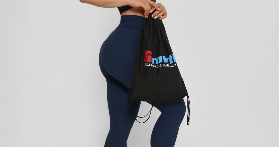 Foto de uma mulher usando legging segurando uma sacola tipo mochila da Growth Supplements